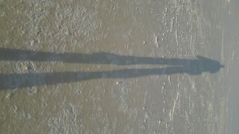 4k30 persona caminando en el lago salado seco en australia - sombra humana a la luz del sol