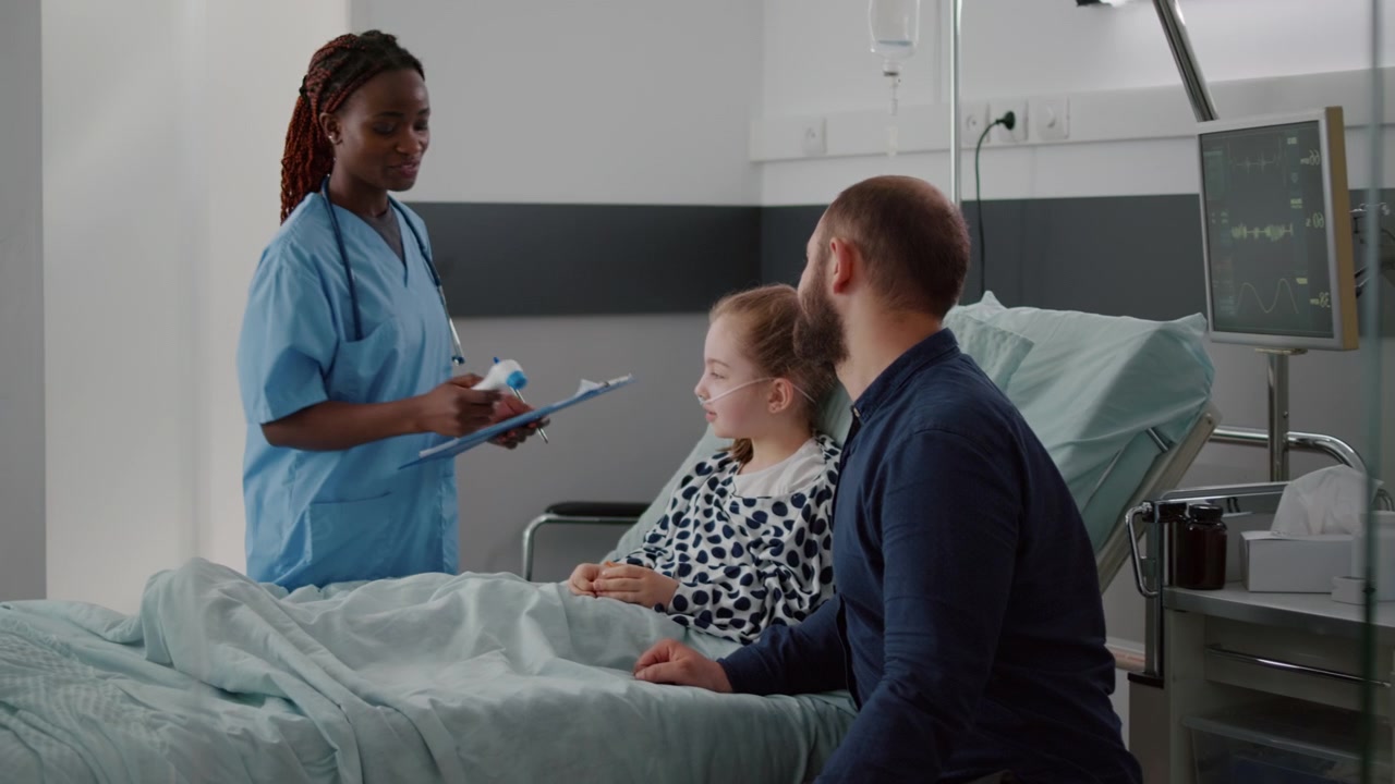 Sygeplejerske tjekker temperatur på ung patient på hospitalsstue