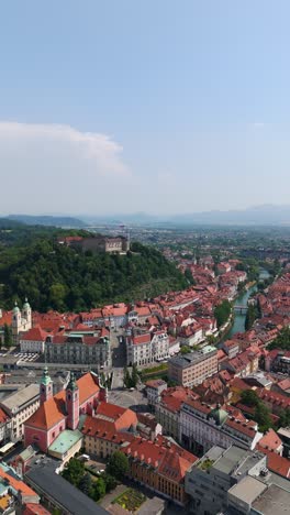 stunning vertical aerial view of ljubljana’s city center, castle, and old town under a blue sky
