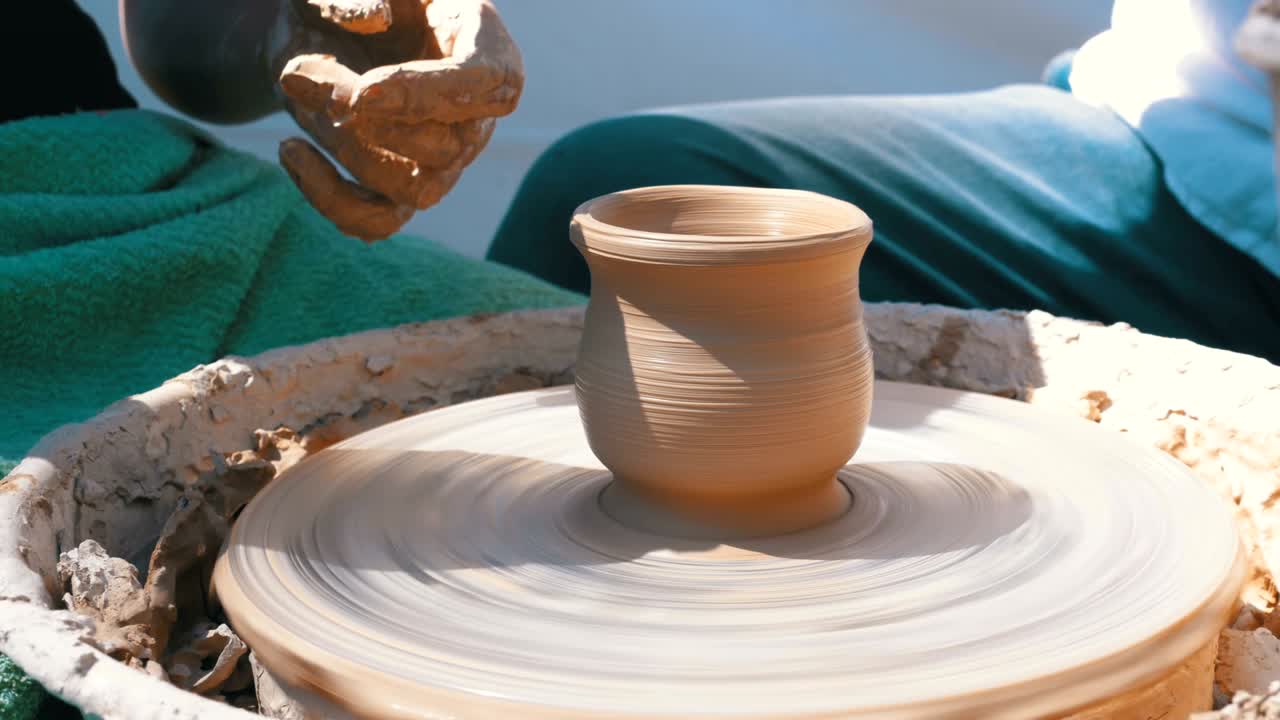 도자기의 손은 도자기의 바에서 점토로 일합니다.