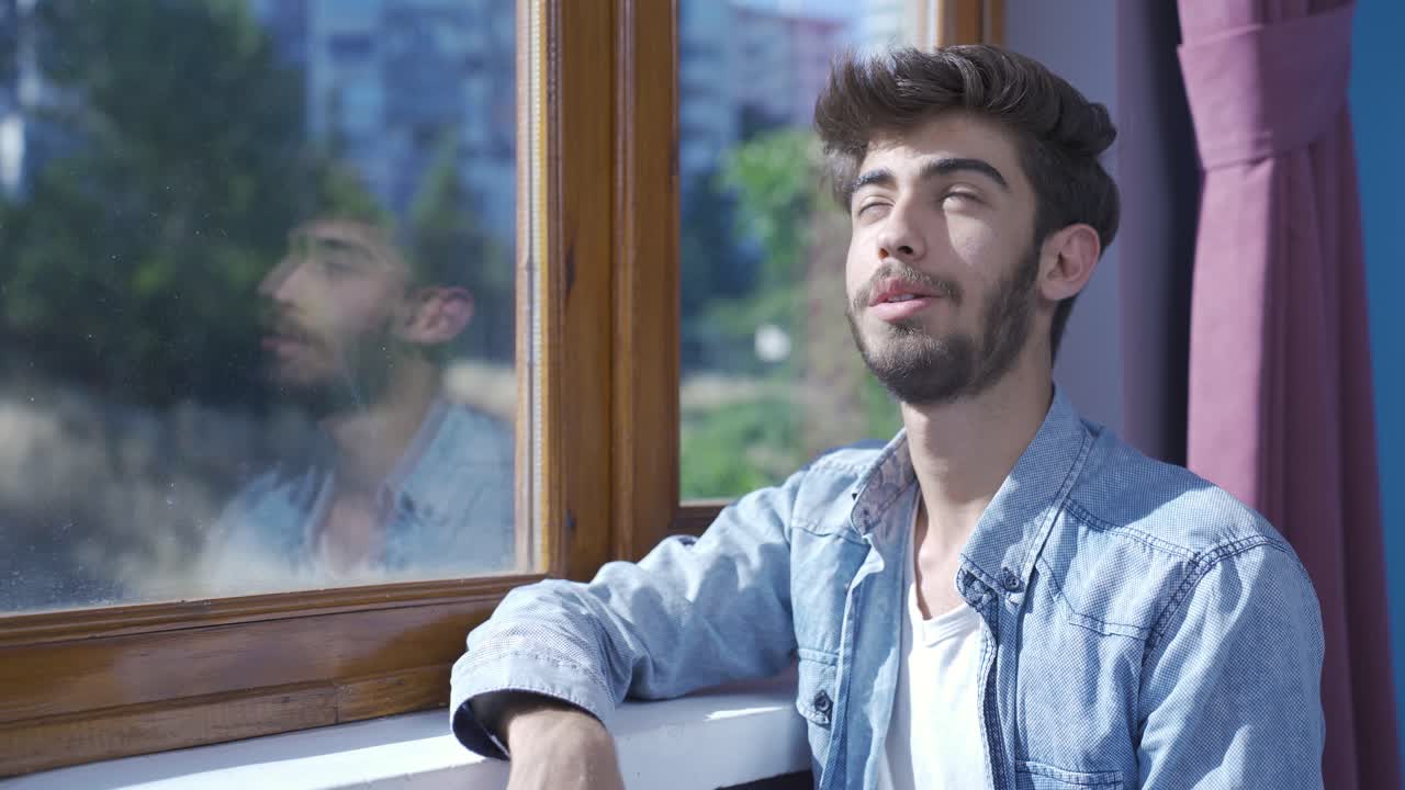 en la ventana el hombre está soñando despierto y riendo.