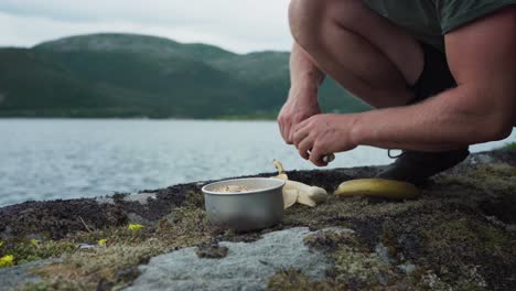 pelar y cortar plátanos para el desayuno de avena por el lago enfoque