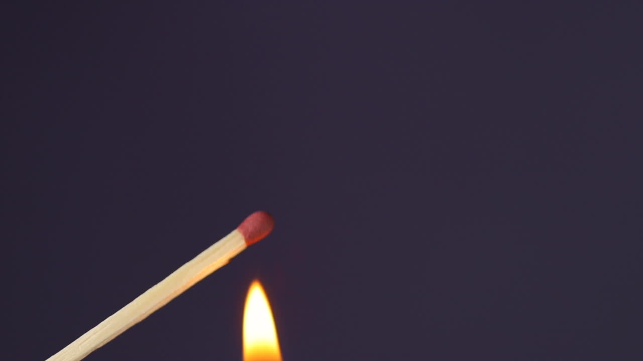 fósforos encendidos a mano primer plano macro capturado desde el lado izquierdo y fuego lateral sobre fondo negro en cámara lenta a 120 fps