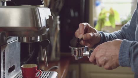 hombre mayor haciendo café en casa