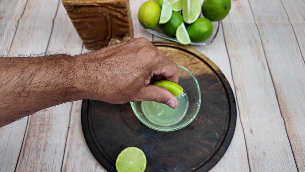 Man squeezes limes top down, fresh citrus juice concept, indoors