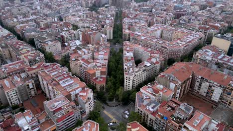 una vista aérea de una carretera de 4 cuadrados con edificios de gran altura y la catedral de la sagrada familia en la distancia