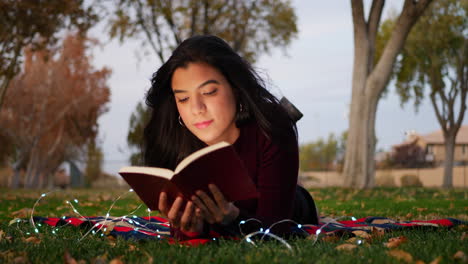 una mujer joven atractiva que abre las páginas de un libro y lee un capítulo de la diapositiva de la historia hacia la izquierda