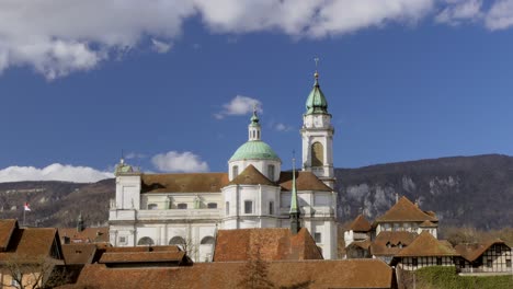 timelapse shot of historic church cathedral and moving clouds on blue sky in background in solothurn,switzerland