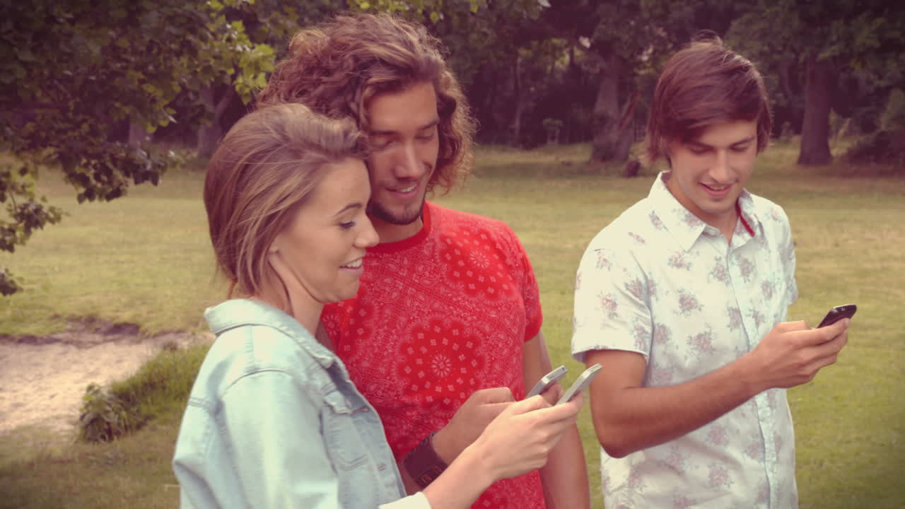 en formato de alta calidad amigos felices en el parque usando sus teléfonos
