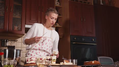 woman preparing a layered dessert in the kitchen