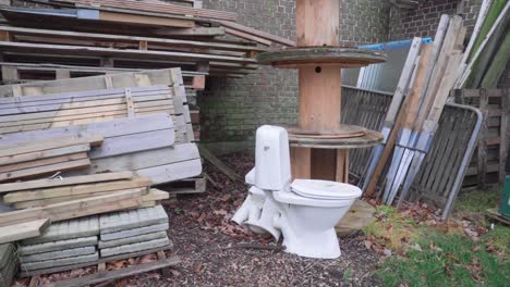 a white toilet abandoned, dumped, left behind outside