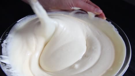 woman chief mixing mass of dough with wooden spoon