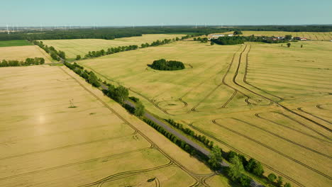 aerial view of fields and countryside with road and wind turbines