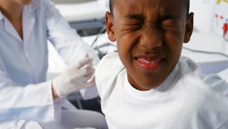 doctor giving an injection to a boy