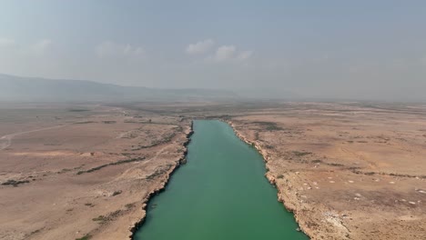 flying above bluish green river with motionless water in northern socotra, yemen