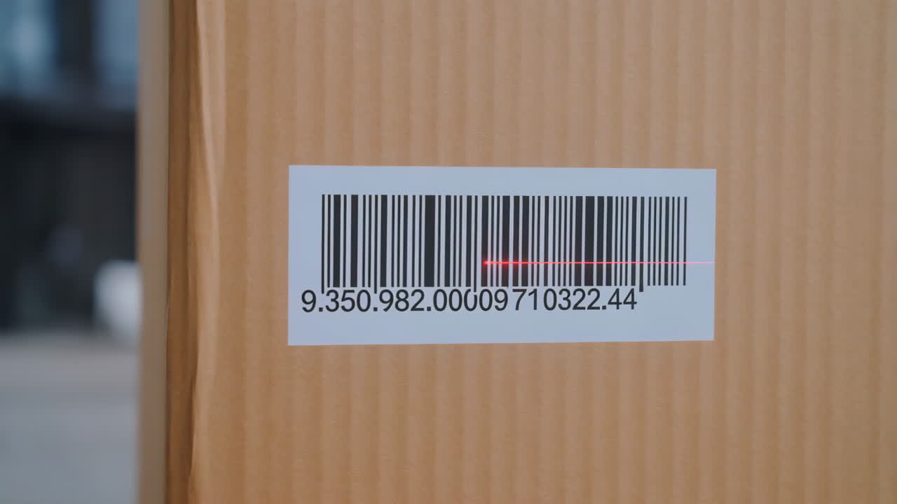Close-up of a red laser scanning a barcode on a cardboard box