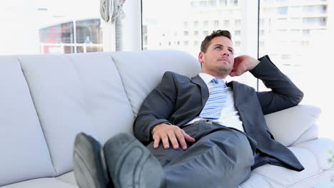 un hombre de negocios relajándose en el sofá.