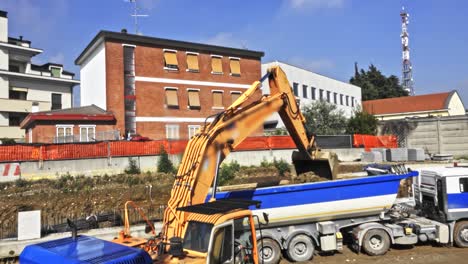 Schwerlastbagger-Auf-Wohnprojekt,-Der-Land-In-Einen-Lastwagen-Bewegt