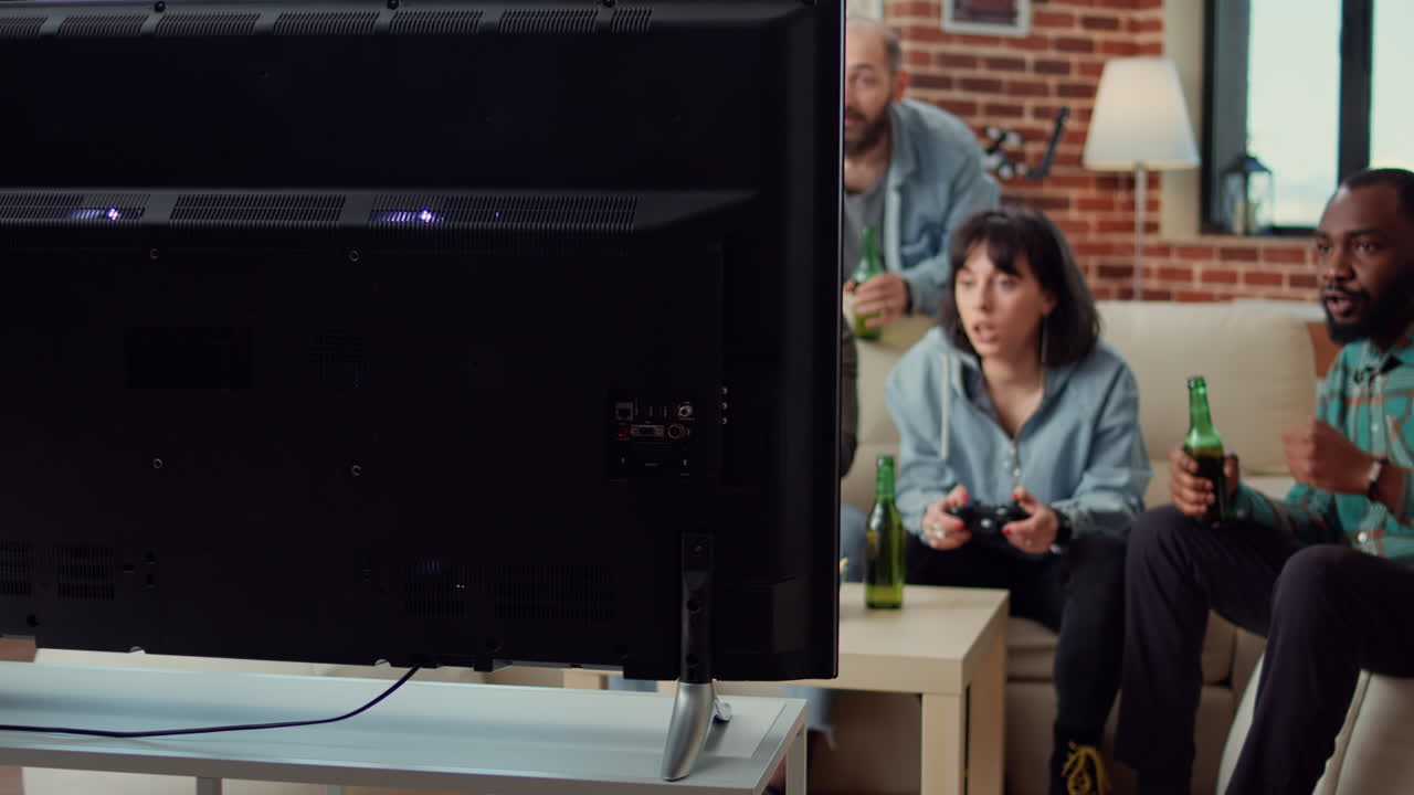 Group of friends playing video games on television console