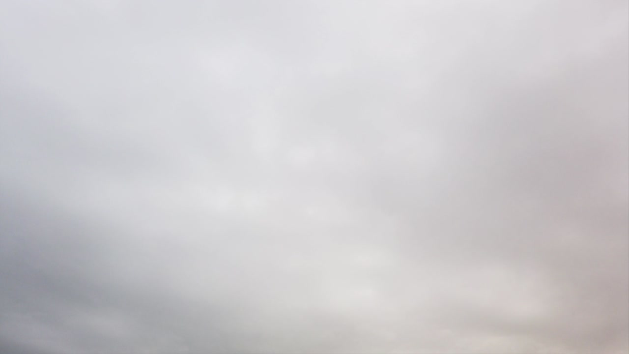 Bad and cold weather with white snowy wet-looking swollen sky with nimbostratus clouds  in time lapse