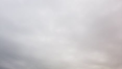 bad and cold weather with white snowy wet-looking swollen sky with nimbostratus clouds  in time lapse