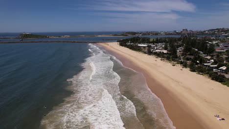 foamy waves splashing at stockton beach in new south wales, australia - aerial shot