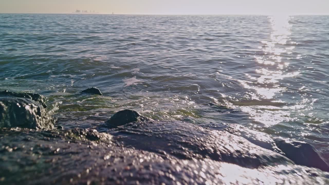 close up view from sunny seashore to the North sea ocean in Europe with splashing water waves and sunlight