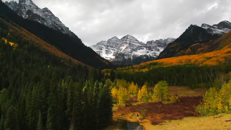 colorful colorado cinematic aerial drone aspen maroon bells capital peak wilderness 14ers autumn fall aspen trees first snow cloudy sunny morning dramatic incredible landscape forward pan up motion