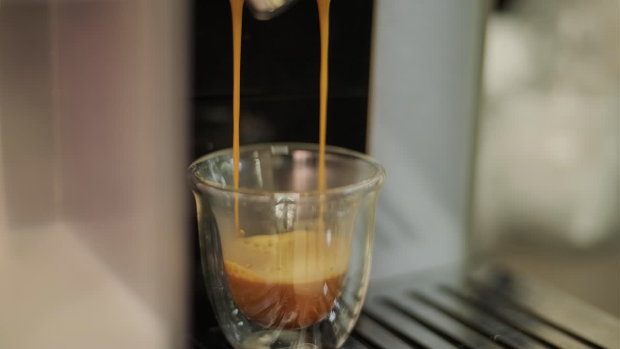 video de cerca de hacer café de taza de vidrio fresco en la máquina de café en la cafetería