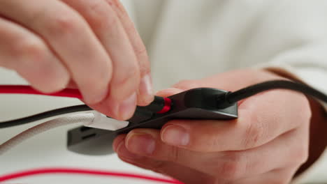 Using special adapter with many various of connector close-up. Adapter with phone, headphones, usb connectors.Tangled wires on table. Trying to untangle many messy cables.