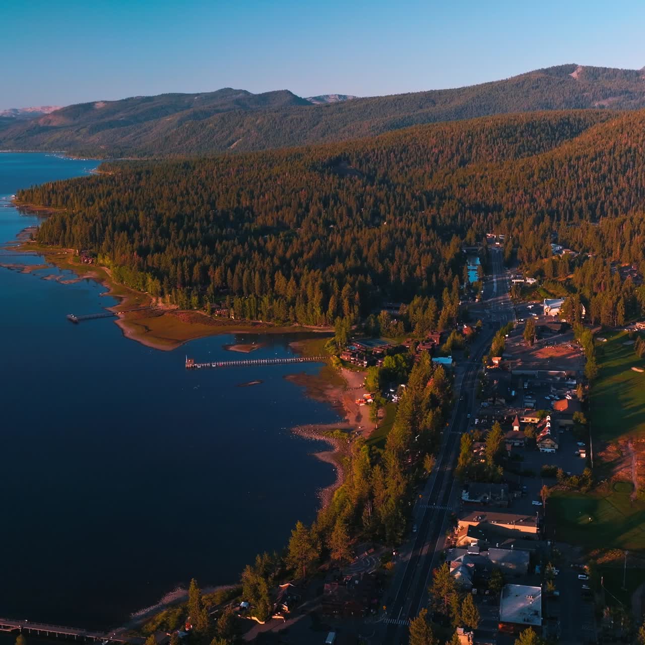 Stunning scenery of beautiful Lake Tahoe on sunny warm day. Waterfront with all the necessary infrastructure and blue water of lake with numerous boats. Top view