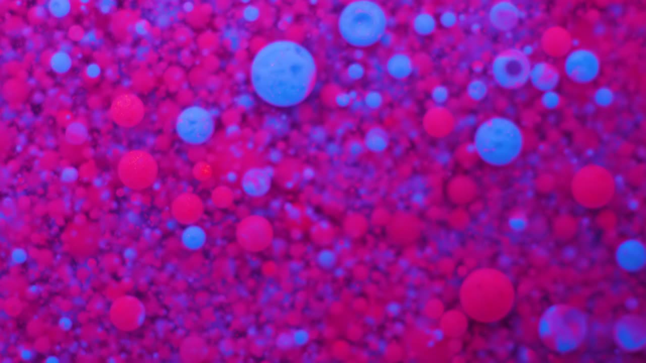 Slow Motion Bright Neon Color Bubbles Oil Beautiful Fluorescent Paint Sparkling Color Moving Multicolor Close up. Acrylic Neon Paint. Fantastic Surface. Abstract Colorful Transformation Gravitation.
