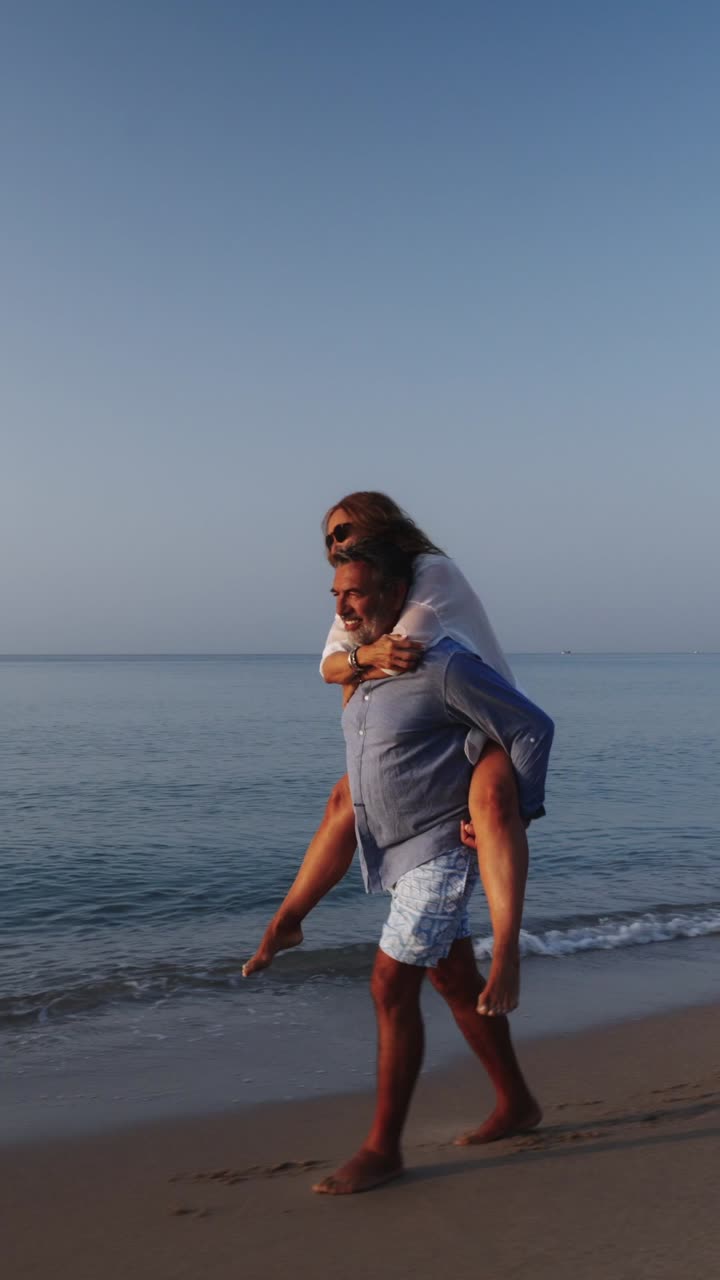 Par nyder en tur på ryggen på stranden