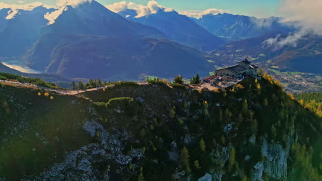 Mountain-top-fortress-overlooking-an-overgrown-valley,-clear-sky,-aerial-view