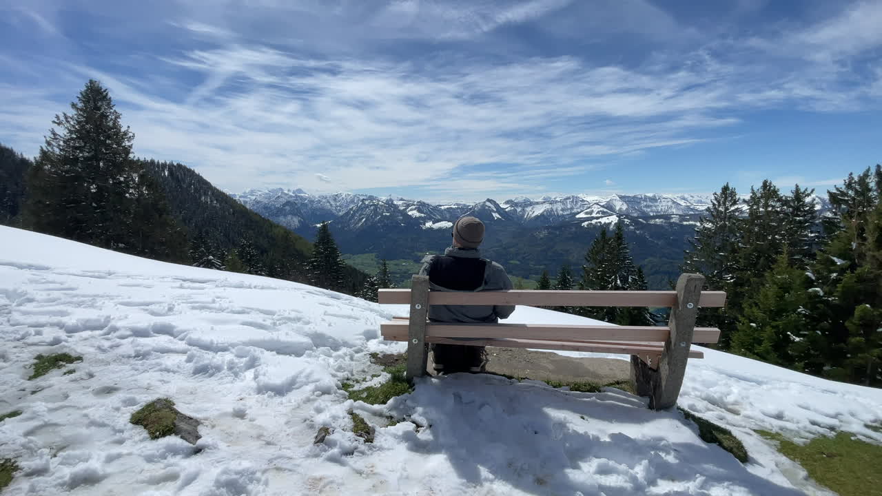 turista sentado en un banco después de hacer una caminata en la cima de schafsberg en austria, salzkammergut sankt wolfgang