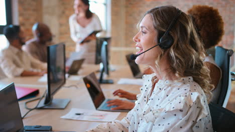 Mujer-De-Negocios-En-Un-Equipo-De-Negocios-Multicultural-Usando-Auriculares-En-El-Centro-De-Atención-Al-Cliente.