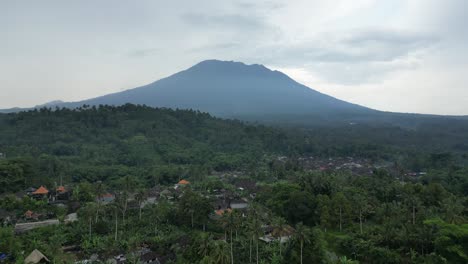 A-cloudy-morning-near-Sidemen-in-Bali,-Indonesia-with-an-epic-volcano-view-of-Mount-Agung,-aerial