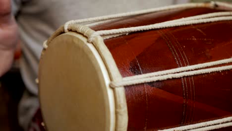 close up of hands of a man playing a drum.