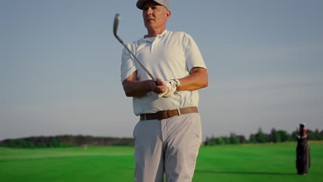 golf player enjoy hobby on green course. old man watch golfing ball on fairway.