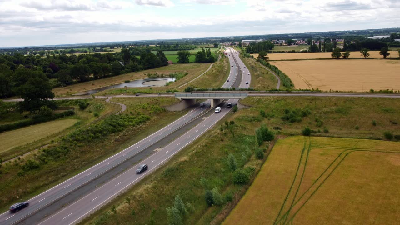 Aerial footage over Norfolks NDR. Footage slowly lowers whilst vehicle drive along the Broadland Northway with middle road bridge,