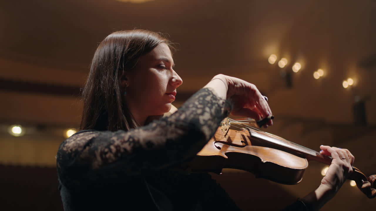 una talentosa violinista está tocando el violín en la sala filarmónica una músico en la orquesta sinfónica