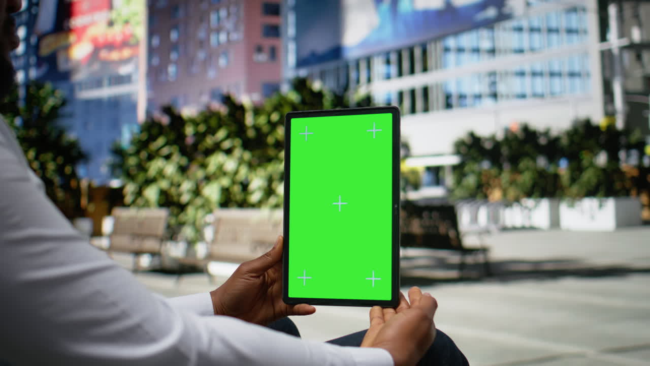 Vertical chroma key with african american seated on a bench in urban park