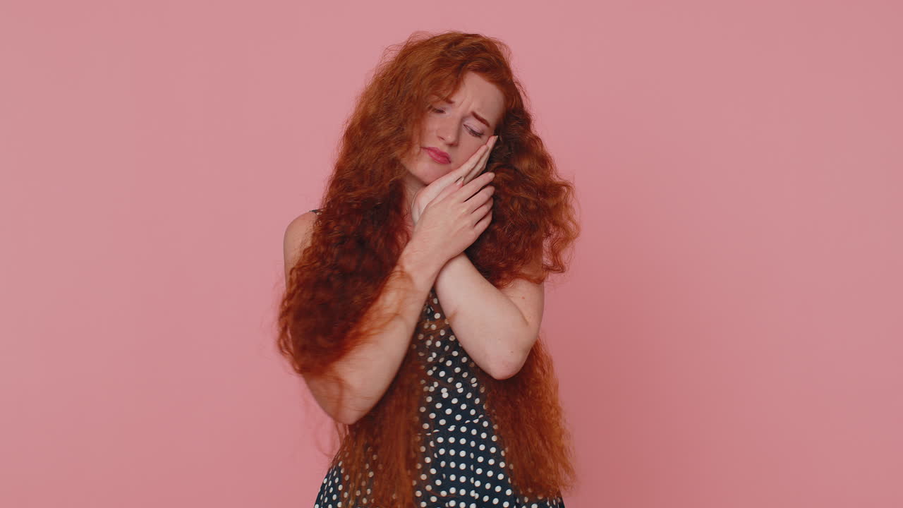 una joven pelirroja sufre de dolor de dientes doloroso, dientes sensibles, caries, problemas dentales
