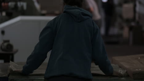 woman lining plastic bags in a factory floor