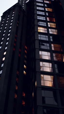 a tall modern skyscraper with illuminated windows at night