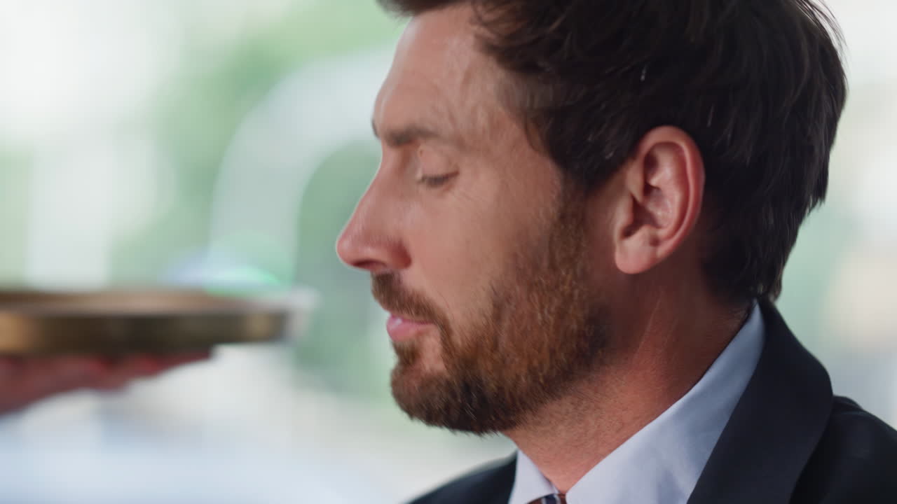 Thoughtful businessman waiting coffee in contemporary cafe closeup. Portrait man
