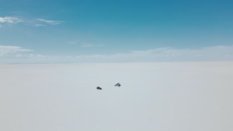 maravíllese con la vasta extensión del salar de uyuni de bolivia con impresionantes imágenes de drones que capturan pequeños jeeps atravesando las interminables llanuras de sal desde arriba