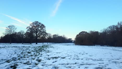 Grass-field-in-countryside-covered-in-white-snow-in-winter-in-England