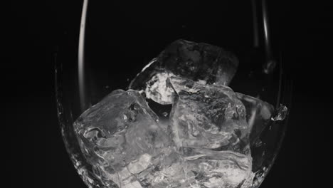 frozen blocks falling wineglass closeup slow motion. thirst quencher concept