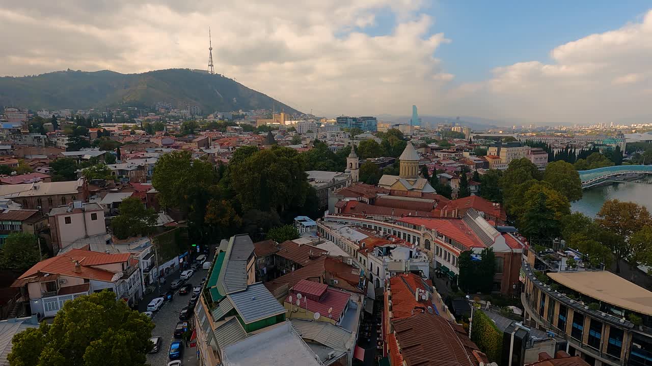 Cable car ascending above Tbilisi showing rooftops and city streets below